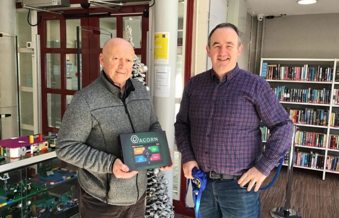Library User Paddy Dunne collecting an ACORN tablet in Nenagh library from Senior Library Assistant John Kelly
